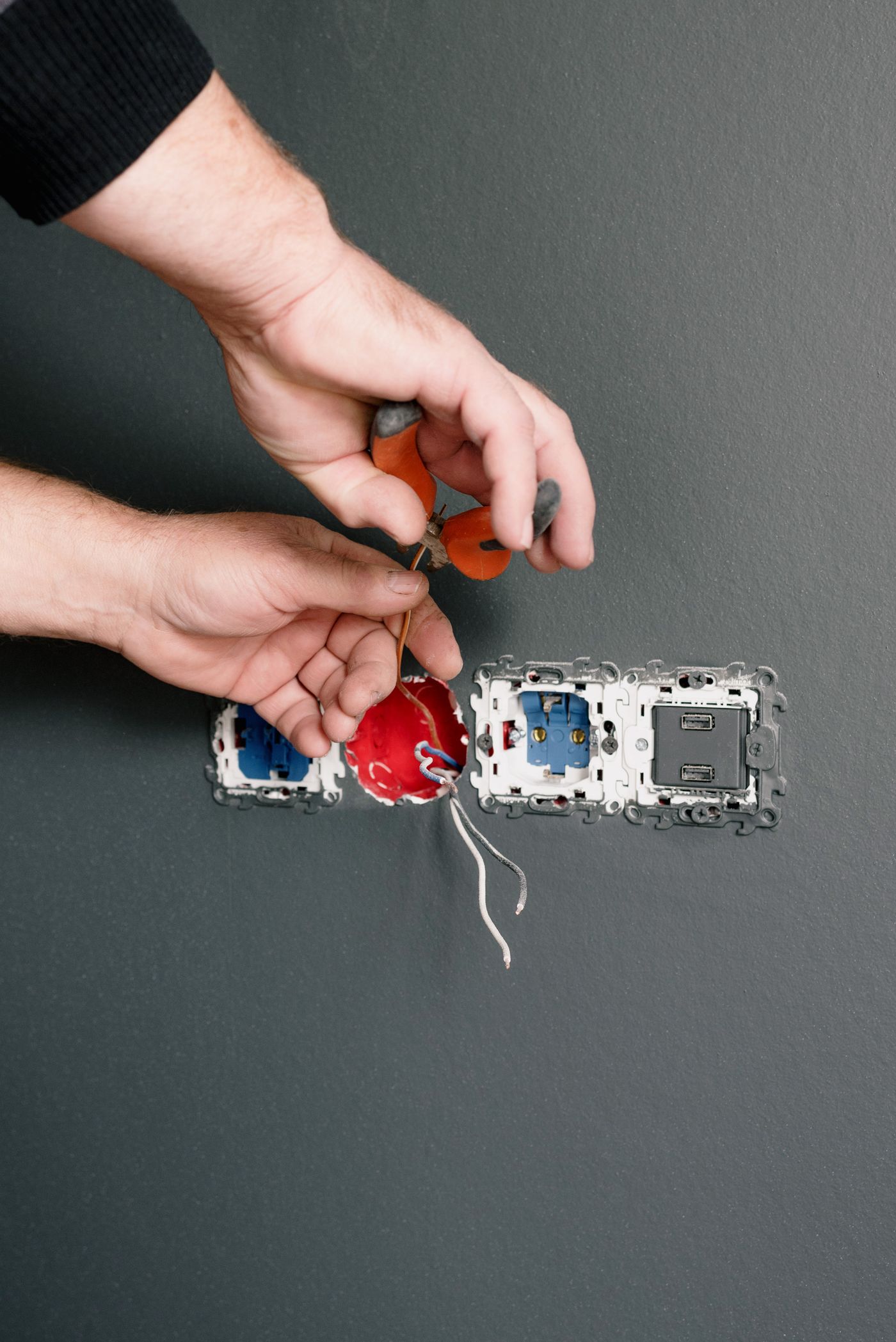 Electrician installing outlets and switches in a home wall